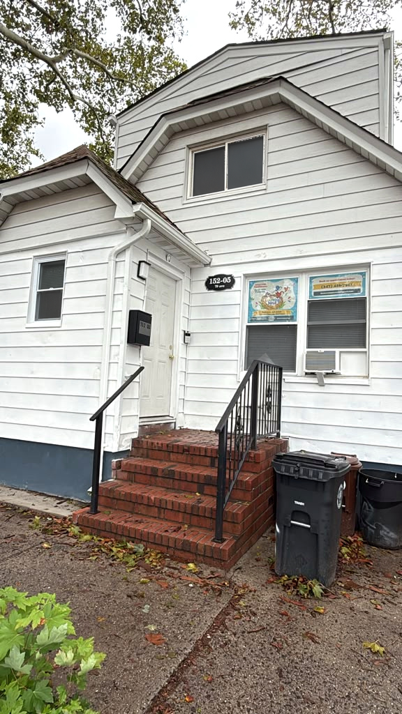The Learning Nest entrance at 152-05 79th Avenue, with brick steps, black railings, and colorful clinic signs in the windows.